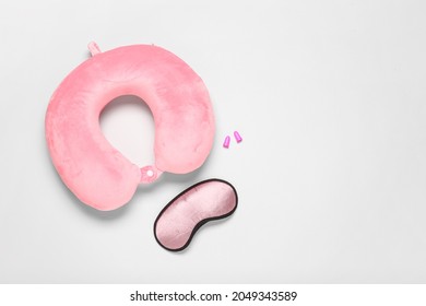 Travel Pillow With Sleep Mask And Ear Plugs On Light Background