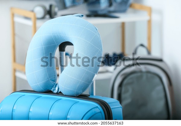 Travel pillow and suitcase in
room