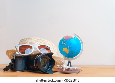 Travel planning for holiday vacation trip concept with camera, airplane model, passport, hat, sunglasses and globe on wooden table and white background - Powered by Shutterstock