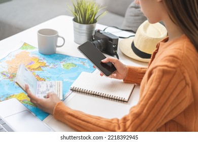 Travel planning, vacation, holiday trip, asian young tourist woman, girl hand using mobile phone, cellphone book flight ticket or check in online with passport, preparation for journey voyage trip. - Powered by Shutterstock