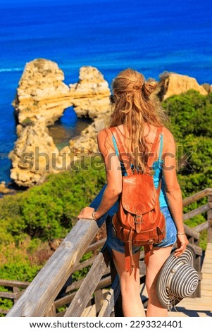 Travel in Portugal- woman looking at beautiful algarve beach and rock formation- Albufeira, Priai da Marinha