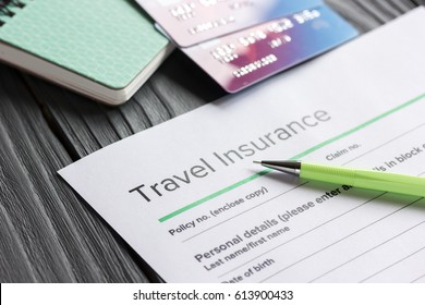 Travel preparation concept with insurance and cards on wooden table