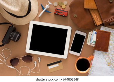 Travel preparations, vacation planning concept concept. Top view on beige table with tourist casual stuff and blank smartphone and tablet, copy space - Shutterstock ID 674802349