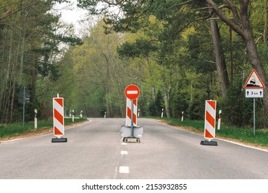 Travel restrictions, road closed, borders closure, borders closed, empty road and forest with stop sign and barriers 