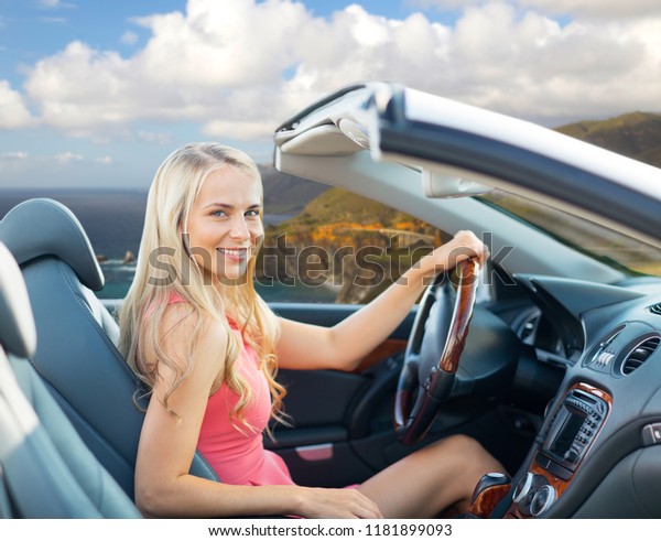 travel, road trip and people\
concept - happy young woman driving convertible car over bixby\
creek bridge on big sur coast of california\
background