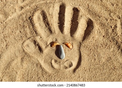 Travel Sadness: Palm Print On Sea Sand - Sad Face - Eyes - Seashells, Nose - Sea Stone, Top View