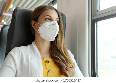 Travel Safely On Public Transport. Young Woman With KN95 FFP2 Face Mask Looking Through Train Window. Train Passenger With Protective Mask Travels Sitting In Business Class Looking Through The Window.