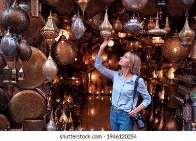 Travel And Shopping. Young Traveling Woman With Choose Presents In Copper Souvenir Handicraft Shop In Morocco.