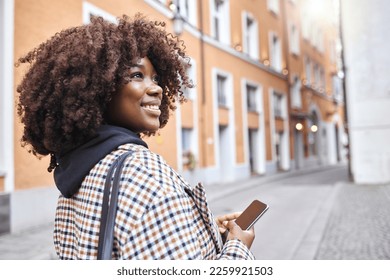 Travel, smile and black woman in street with phone, holiday sightseeing in London, happy tourist walking in road. Vacation, urban adventure and relax, 5g on walk with buildings and explore new city. - Powered by Shutterstock