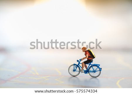 Travel and Sport Concept. Miniature people figure of man ride bicycle on map