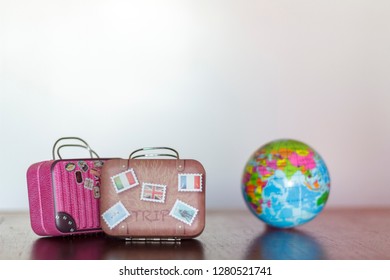Travel Suitcases and earth globe on a table with white background and copy space. Travel concept - Shutterstock ID 1280521741