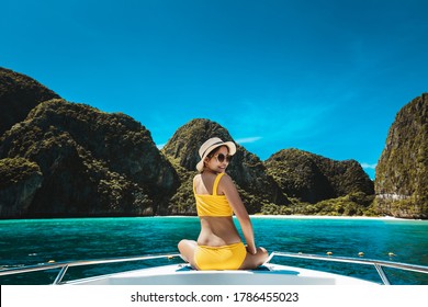 Travel Summer Vacation Concept, Happy Solo Traveler Asian Woman With Bikini And Hat Relax On Boat In Maya Bay Phuket Thailand