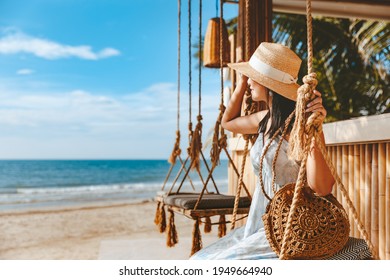 Travel summer vacation concept, Happy traveler asian woman with hat and dress relax on swing in beach cafe, Koh Chang, Thailand - Shutterstock ID 1949664940