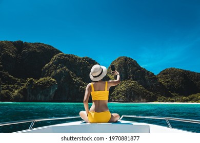 Travel Summer Vacation Concept, Happy Solo Traveler Asian Woman With Bikini And Mobile Phone Relax And Selfie On Boat In Maya Bay Phuket Thailand