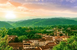 Travel Summer View From Hill To A Nice European Town With Amazing Buildings, Green Hills And Mountains With Amazing Cloudy Evening Sky On Background, Urban Sunset Landscape