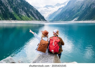 Travel team. Travelers enjoy the view of the mountain valley. Adventure and travel in the mountains region. Mountains and lake. - Shutterstock ID 2035431545