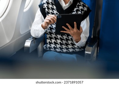 travel and technology Fly in first class Beautiful Asian businesswoman working using laptop computer while sitting on airplane
