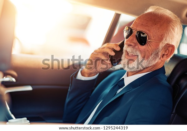 Travel, technology and people concept - senior\
businessman talking on smart\
phone.