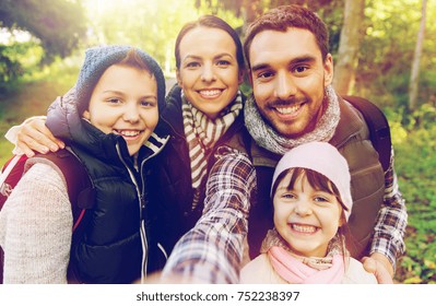 Travel, Tourism, Hike And People Concept - Happy Family With Backpacks Taking Selfie And Hiking