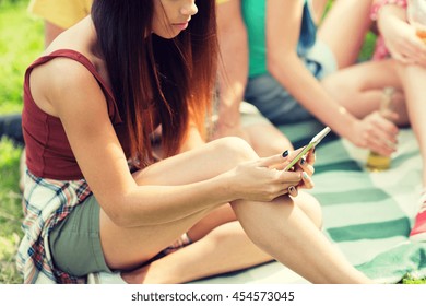 travel, tourism, picnic, technology and people concept - close up of young woman or teenage girl texting on smartphone with friends outdoors - Powered by Shutterstock