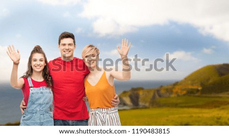 travel, tourism and summer holidays concept - group of happy smiling friends hugging over big sur coast of california background