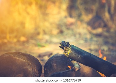 Travel Tourist Forest Concept, Cooking In Bamboo Tube Section For Roast Or Grill On Hills In Camping. Fire Flame Burning To Heat Bamboo And Food By Grill. This Cooking Is Traditional In Countryside.