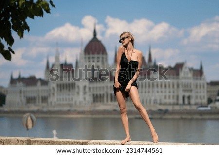 Travel tourist woman in Budapest Parliament in Hungary Europe. High Fashion model girl posing outdoor. Fashion dress. Beautiful woman in high fashionable clothes. Womans Fashion.