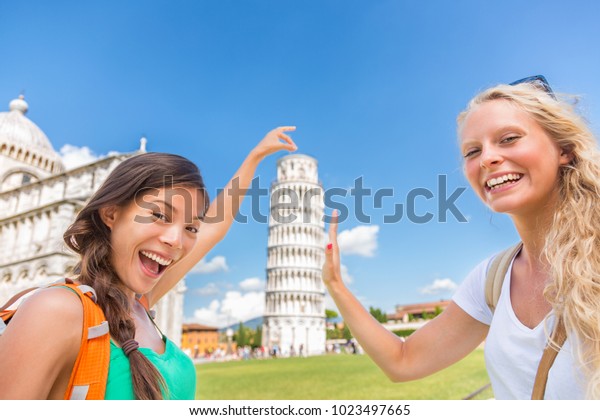 ピサで撮った旅行者の友人が 写真のポーズを楽しみながら自撮します ヨーロッパの夏休みに2人の女の子がバックパッキングをして 人気のアトラクションで 面白いポーズで写真を撮っている の写真素材 今すぐ編集