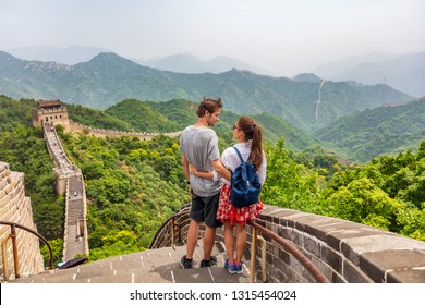 Travel Tourists People Sightseeing In China Travel Vacation. Happy Interracial Couple Enjoying Great Wall Of China Landscape Near Beijing City. Asia Travel Summer Holidays Together.