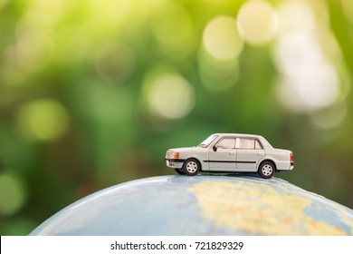 Travel and transport concept. Miniature Toy car on world map balloon with green nature as background. - Powered by Shutterstock