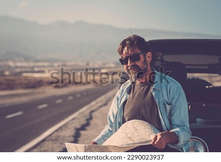 Travel transport people lifestyle. man looking the roads and using paper guide map to find destination and arrival time. Transportation. Summer car vacation driver. People and adventure lifestyle