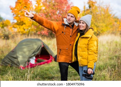 travel, trekking and hiking concept - young couple hikers near green tent in autumn forest - Shutterstock ID 1804975096
