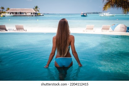 Travel Vacation - Beautiful Young Pretty Blonde Girl Back In Bikini On Her Perfect Sport Sexy Body Relax In Pool Near Paradise Beach At Tropical Caribbean Maldives Beach At Sunny Day In Hotel