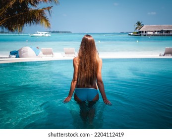 Travel Vacation - Beautiful Young Pretty Blonde Girl Back In Bikini On Her Perfect Sport Sexy Body Relax In Pool Near Paradise Beach At Tropical Caribbean Maldives Beach At Sunny Day In Hotel