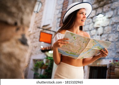 Travel vacation city concept. Young happy traveler woman with map walking