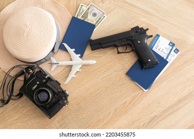 Travel And Vacation Concept, Passport, Money And Gun On Wood Top Table.