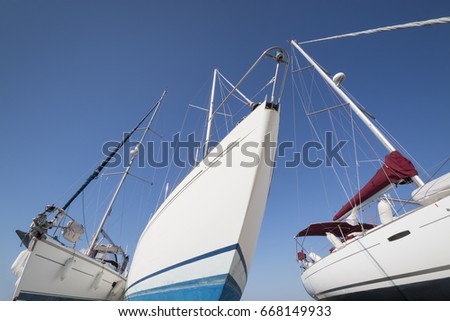 travel or vacation concept with three white  sailing yachts at the boatyard  in front of a blue sky 