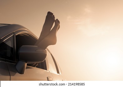 Travel vacation freedom beach vintage concept. Female legs out of car window. - Powered by Shutterstock