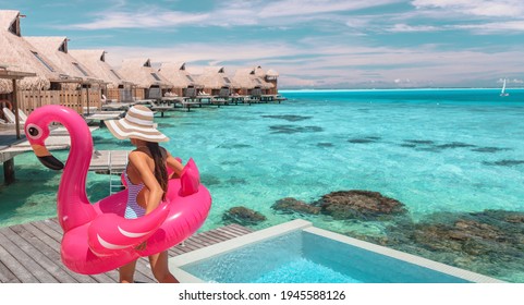 Travel Vacation Fun Tourist Woman Enjoying Luxury Summer Holidays At Bora Bora Overwater Bungalow Swimming With Flamingo Pool Toy Float At Infinity Pool By Turquoise Ocean. Tahiti Getaway Destination.