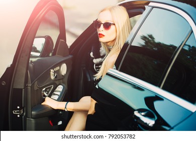 Travel And Vacation. Modern Life, Luxury, City, Glamour. Business Trip Or Commanding, Call Girl. Businesswoman Or Pretty Blonde Girl With Red Lips In Car. Young Woman Get Out Of Car With Sexy Leg.