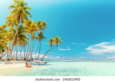 Travel vacation perfect iconic beach with beautiful woman in bikini on private beach island motu relaxing sipping on blue cocktail while sunbathing on French Polynesia travel. Cruise ship destination - Shutterstock ID 1963013905