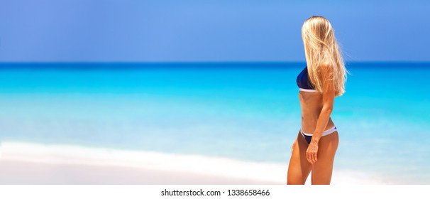 Travel Vacation Widescreen Panorama - Beautiful Young Pretty Blonde Girl In Bikini With White Sand On Perfect Sport Sexy Body Relax In Sea Of White Sand Paradise Tropical Maldive Beach At Sunny Day