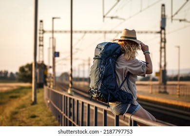 Travel At Vacation. Woman With Backpack Waiting For Train At Railway Station