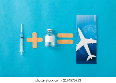 Reise-, Impfungs- und Gesundheitskonzept - Einwegspritze, Arzneimittel, Pflaster und Flugticket auf blauem Hintergrund