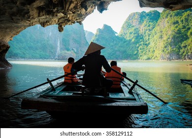 Travel in Vietnam,A young girl paddle a bamboo boat for tourist in the beautiful bay.