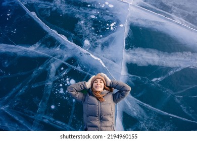 Travel winter Lake Baikal, happy joy woman tourist lie on ice sunset, top view. - Shutterstock ID 2194960155