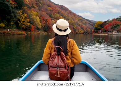 Travel Woman Sit On Travel Boat In River At Arashiyama With Autumn Nature Background