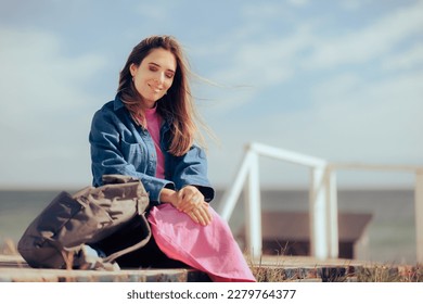 
				Travel Woman Sitting on a Deck Resting and Relaxing Carefree. Beautiful girl traveling alone with her backpack 
				