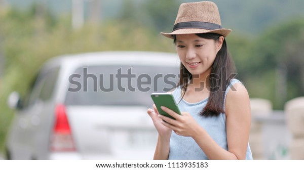 Travel woman think of the location of\
destination on cellphone map between road\
trip