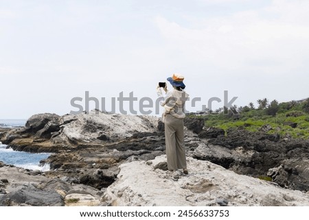 Travel woman use cellphone to take photo at seaside